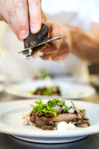 A chef adds truffle shavings to a dish in Taste Washington's dinner series.